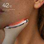 The chrome head of Loomi Glide resting along a jawline with a red light along its edge: 42 °C on red and green.