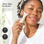 A smiling woman holding Loomi Glide to her cheekbone, with 30-day returns and 90-day warranty stamps.