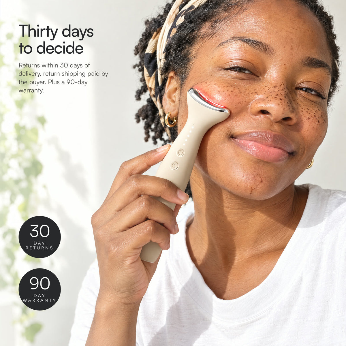 A smiling woman holding Loomi Glide to her cheekbone, with 30-day returns and 90-day warranty stamps.