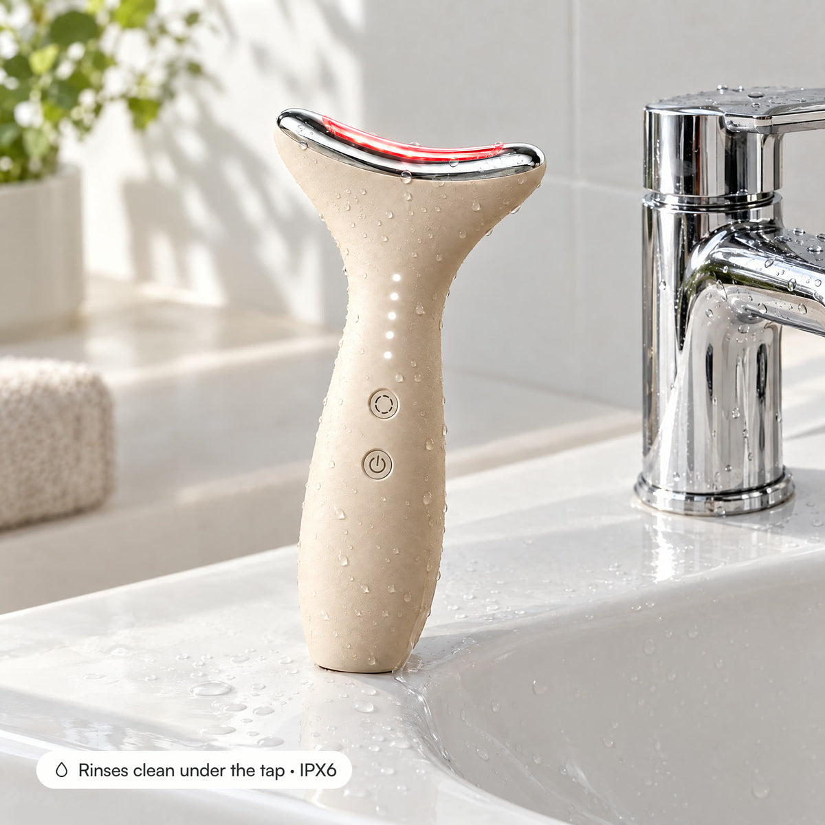 Loomi Glide standing on a wet basin edge with water beads on the handle: it rinses clean under the tap (IPX6).